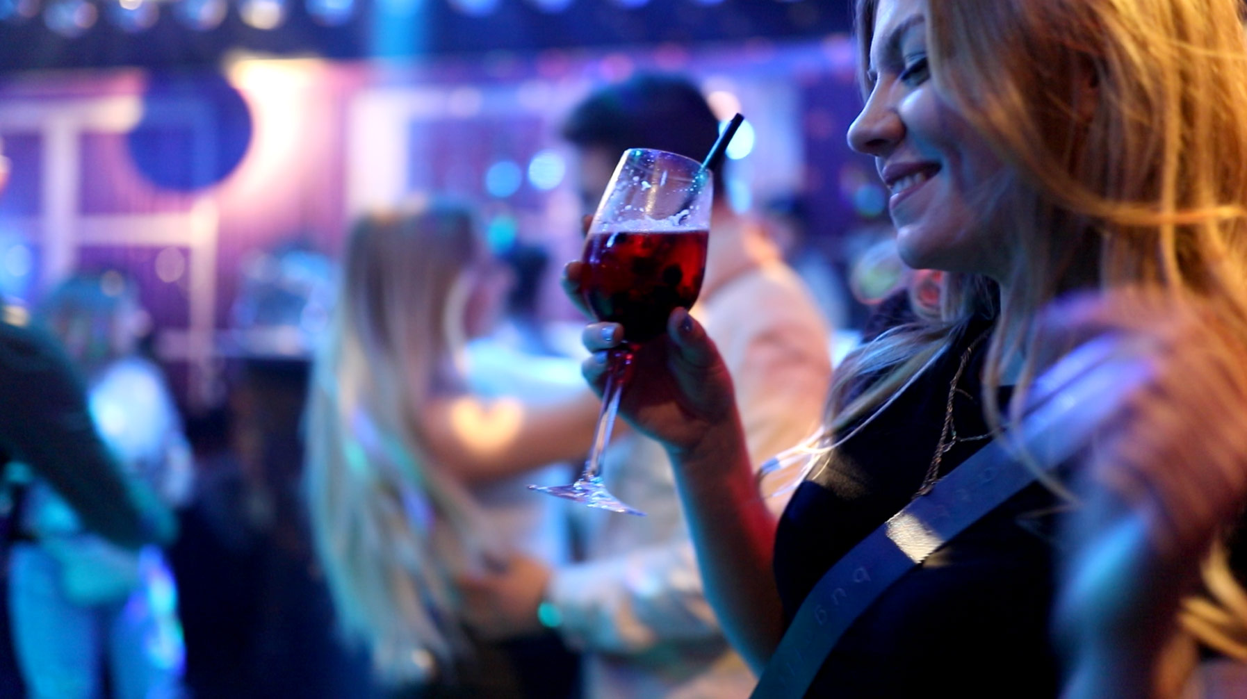 Junge Frau im Club 43 hält Glas in der Hand